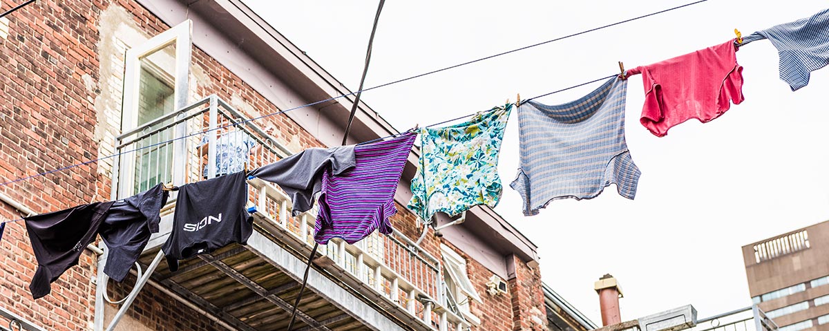 Photo d'une corde à linge avec un mur de briques rouges